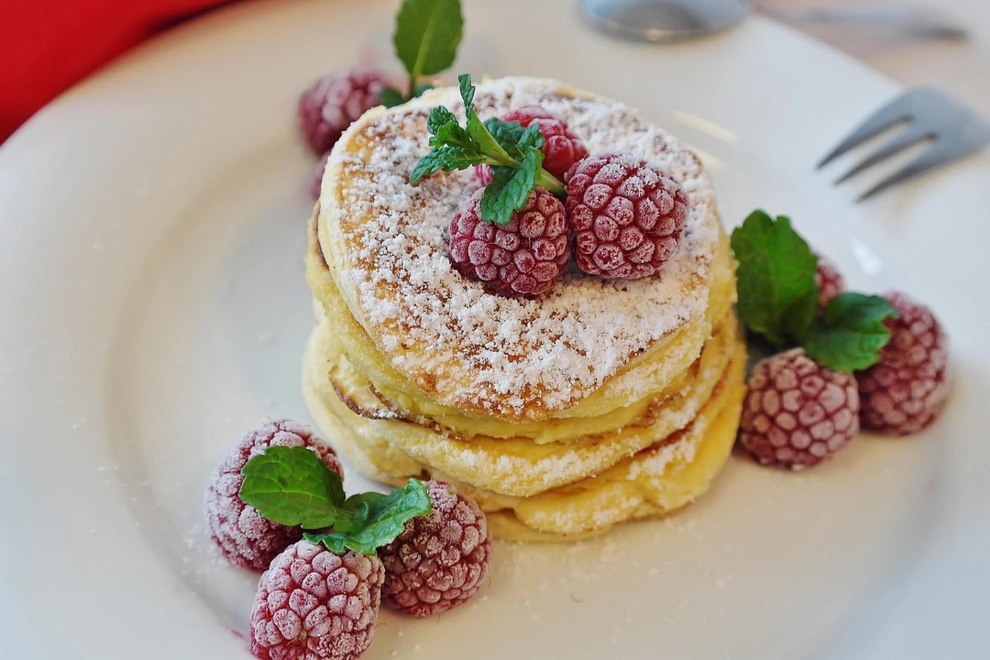 Pila de pancakes americanos esponjosos con frambuesas